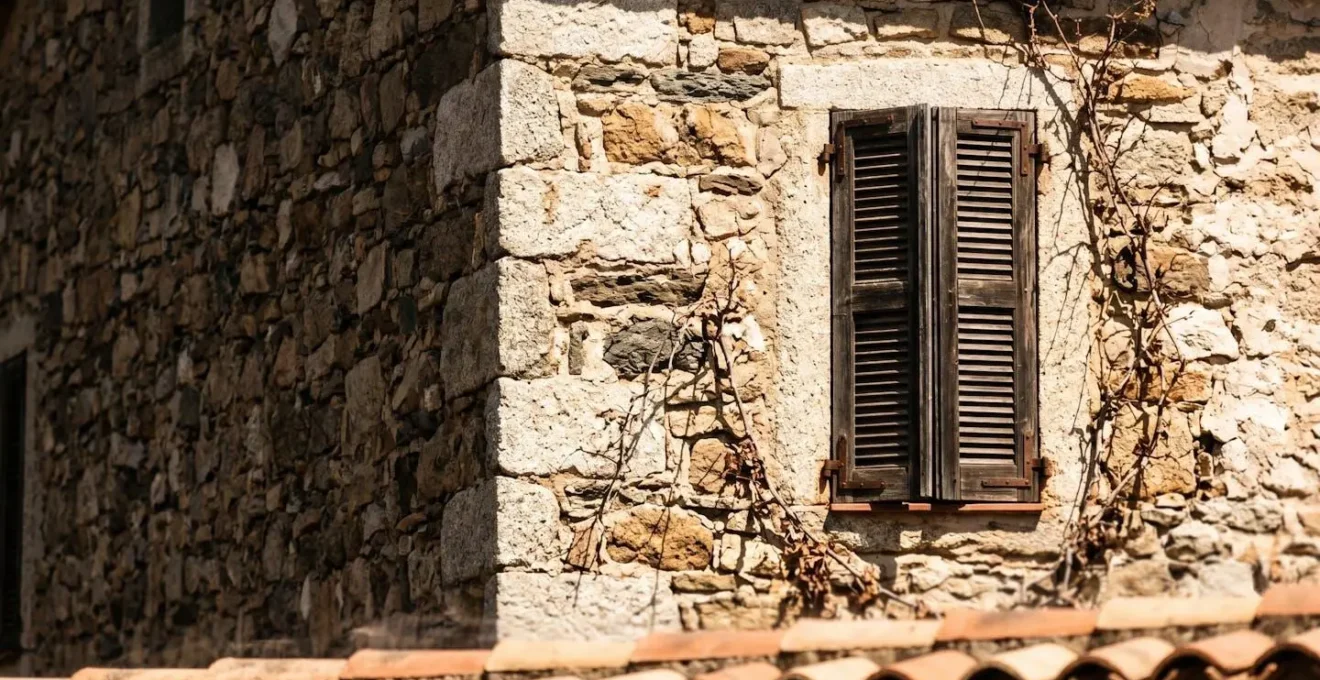 Façade de villa corse en pierre exposée plein sud sous le soleil d'été