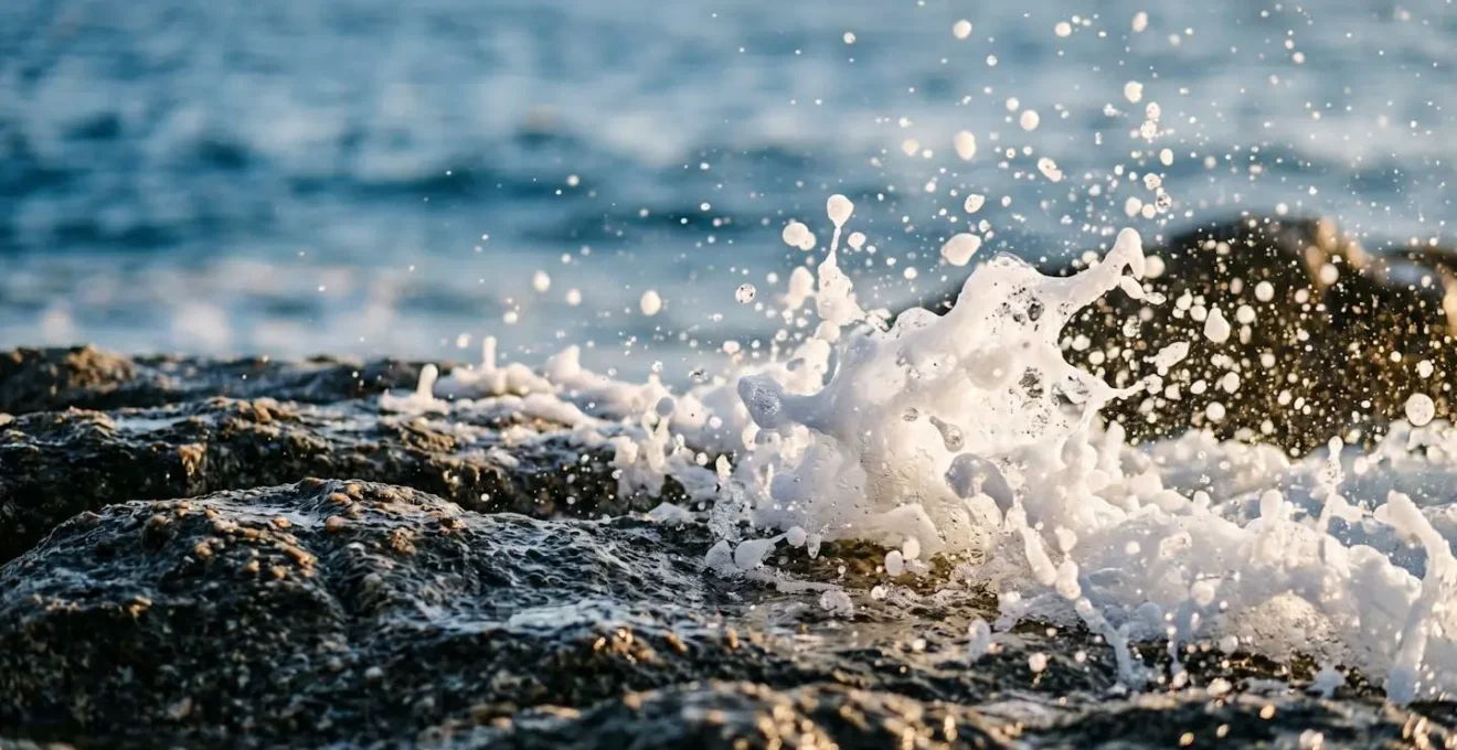 Ecume des vagues se brisant sur les rochers granitiques de la côte corse, gouttelettes d'eau en suspension dans l'air marin